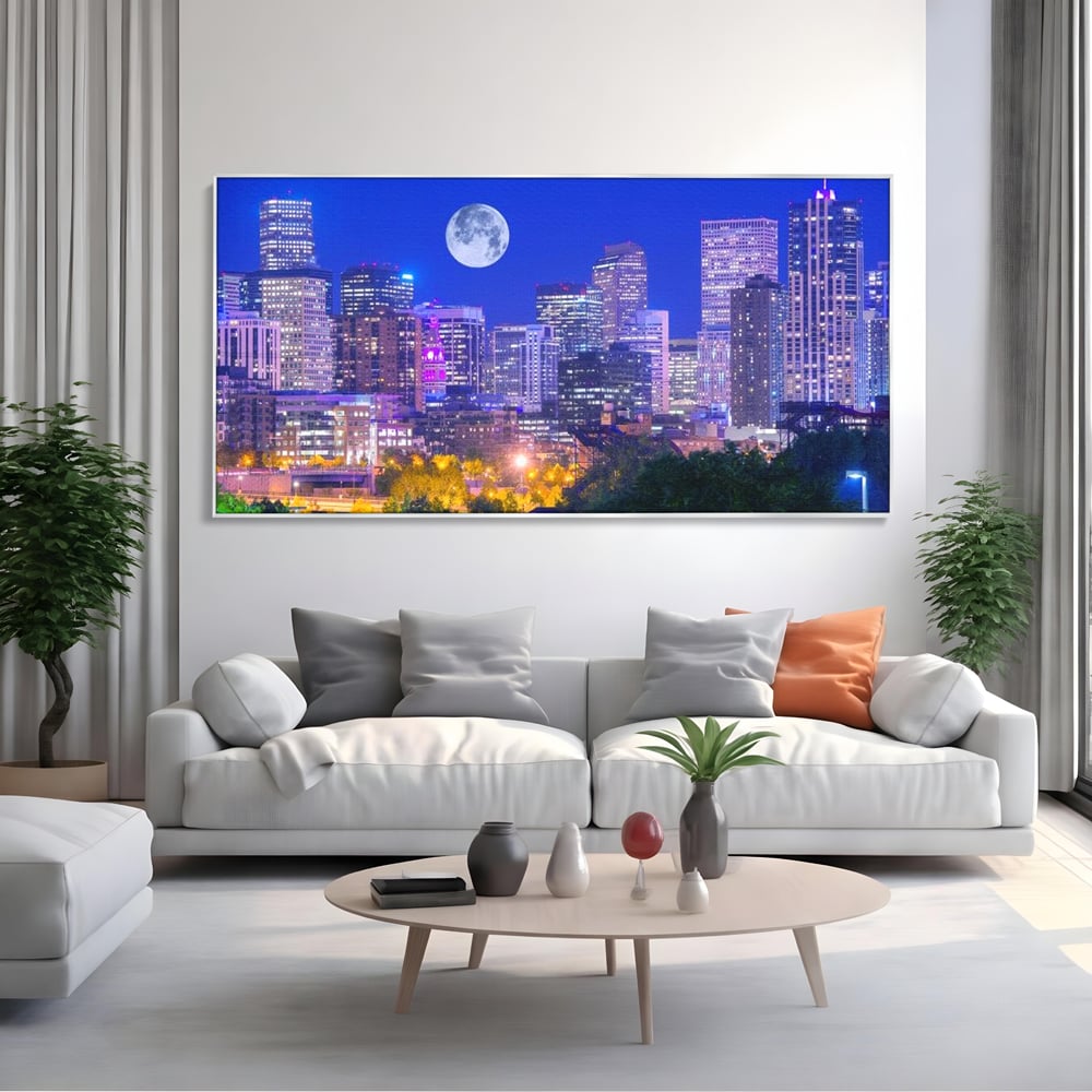 Tablou canvas cu tablou canvas cu peisaj urban nocturn si luna plina, in rama de aluminiu argintiu, pe perete intr-un living